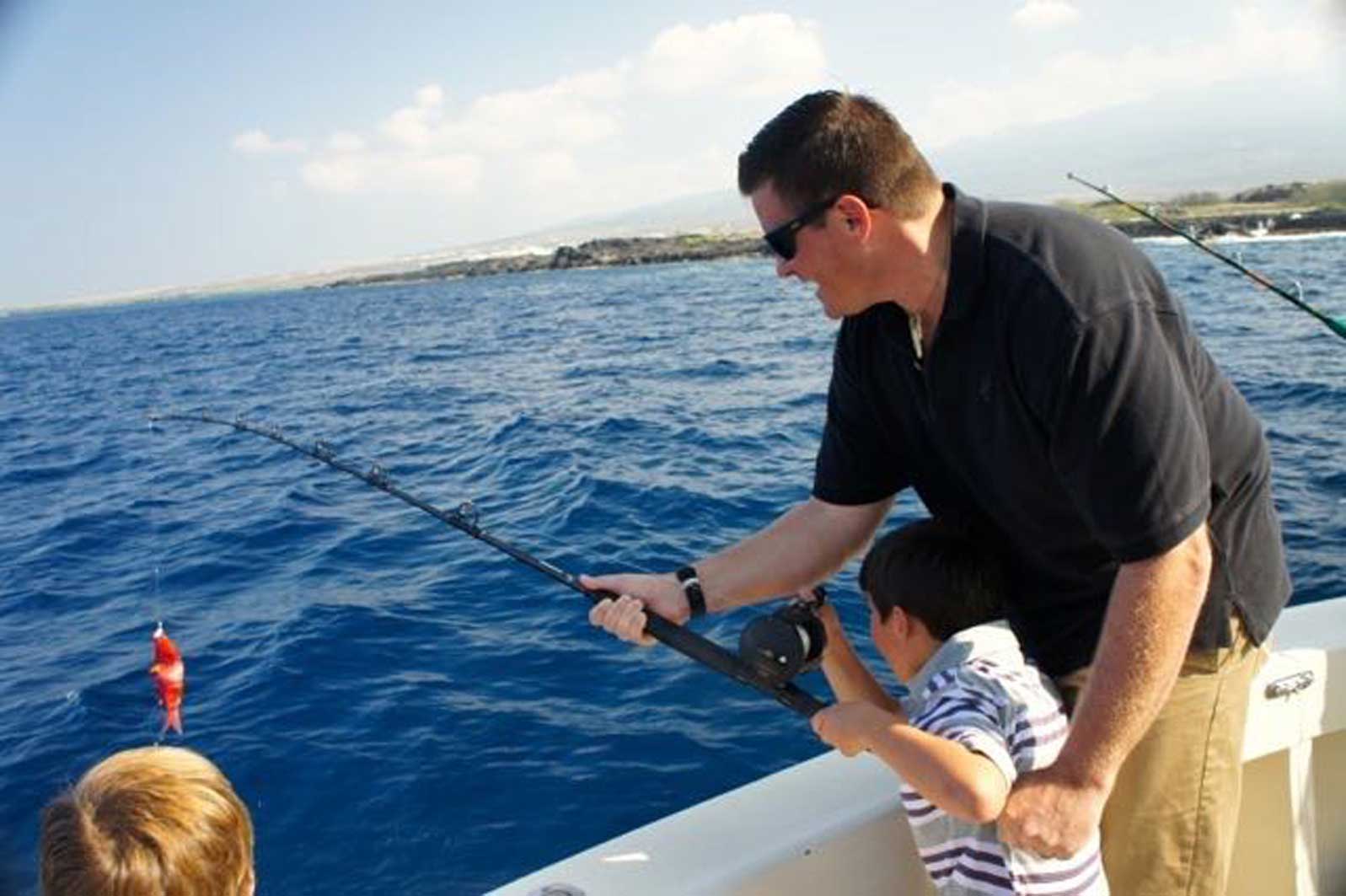 A man and a boy are fishing in the ocean