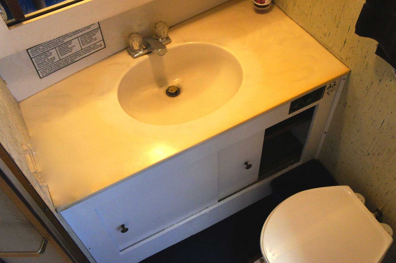 A bathroom with a toilet a sink and a mirror