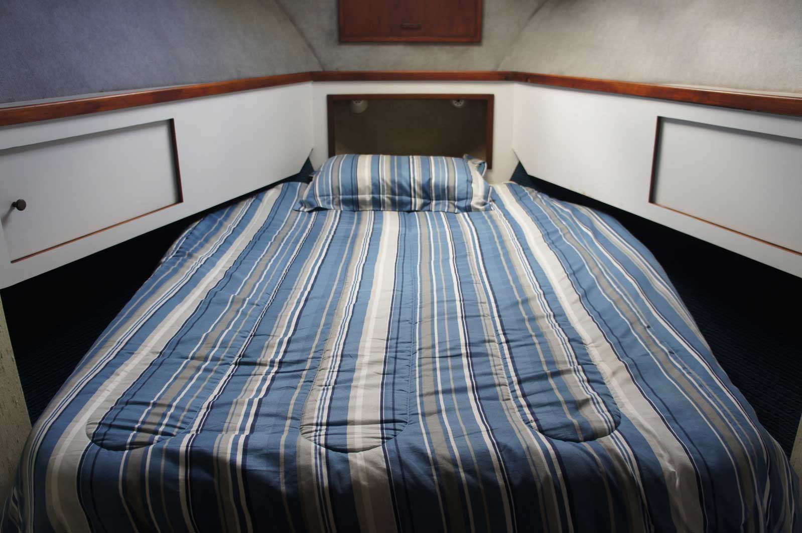 A bed with a blue and white striped comforter