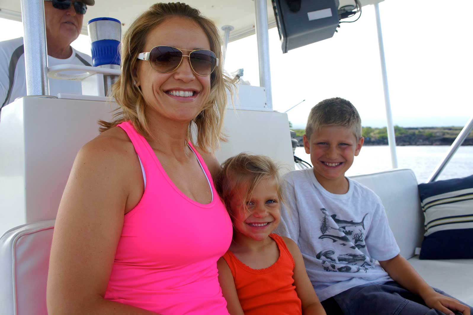 A woman and two children are sitting on a boat.
