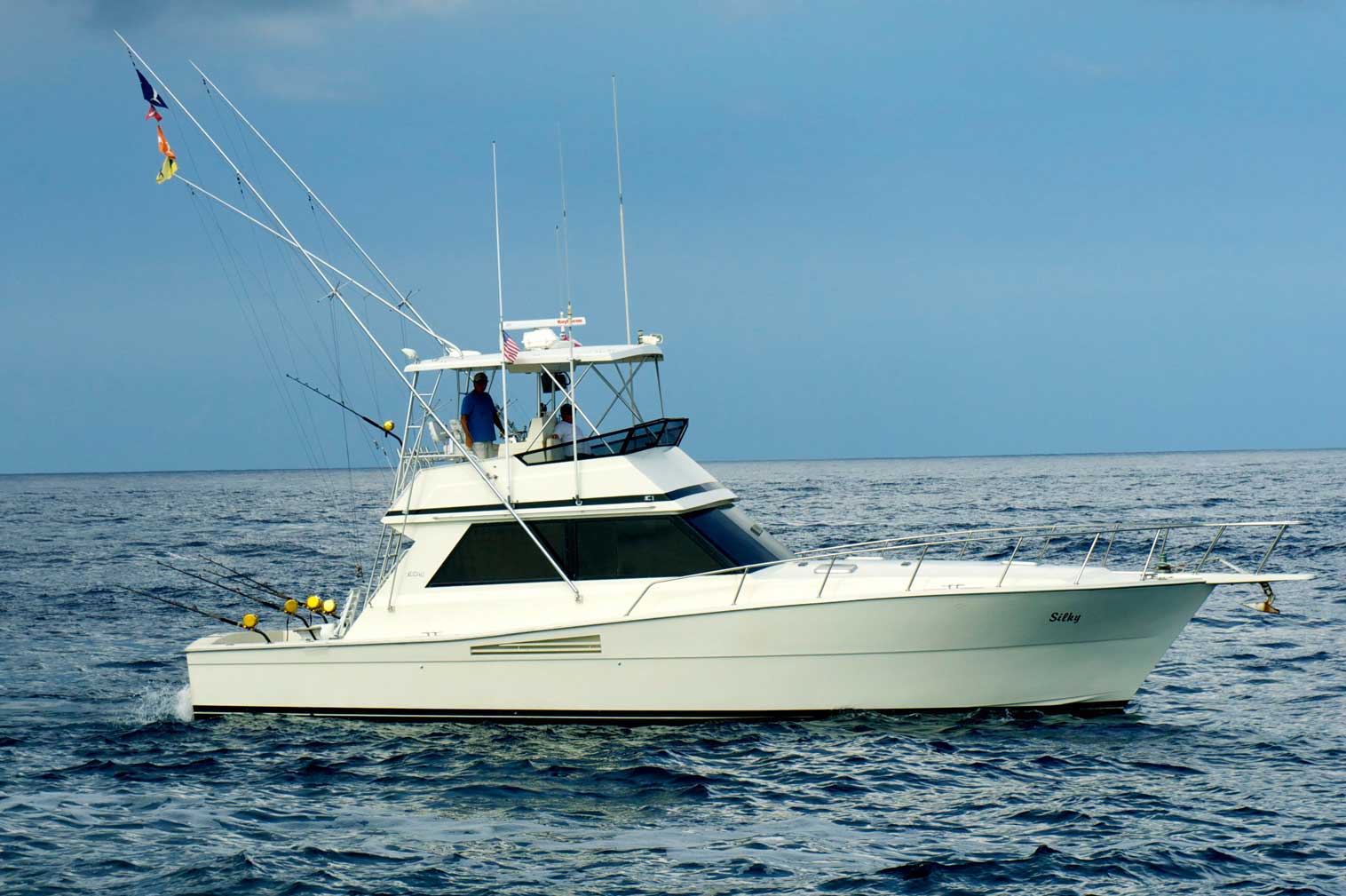 A large white boat is floating on top of a large body of water.