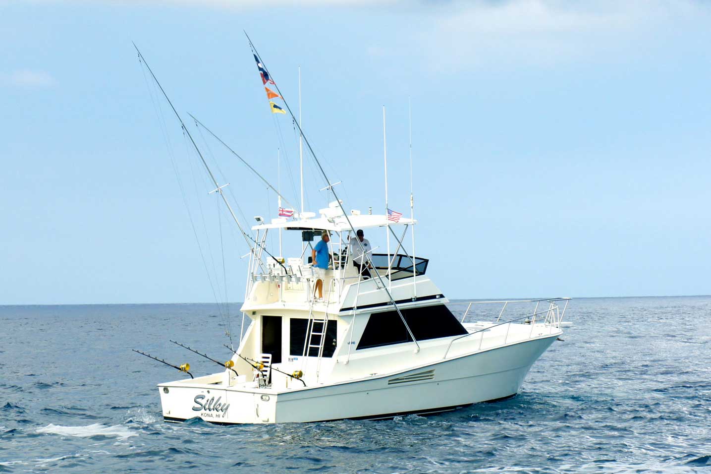A large white fishing boat is floating on top of a large body of water.