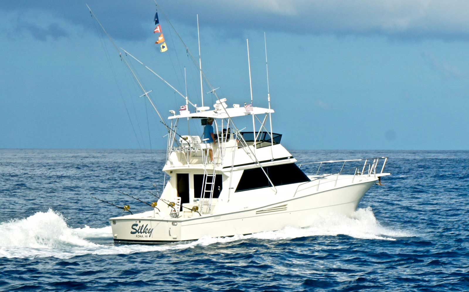 A large white boat is floating on top of a large body of water.
