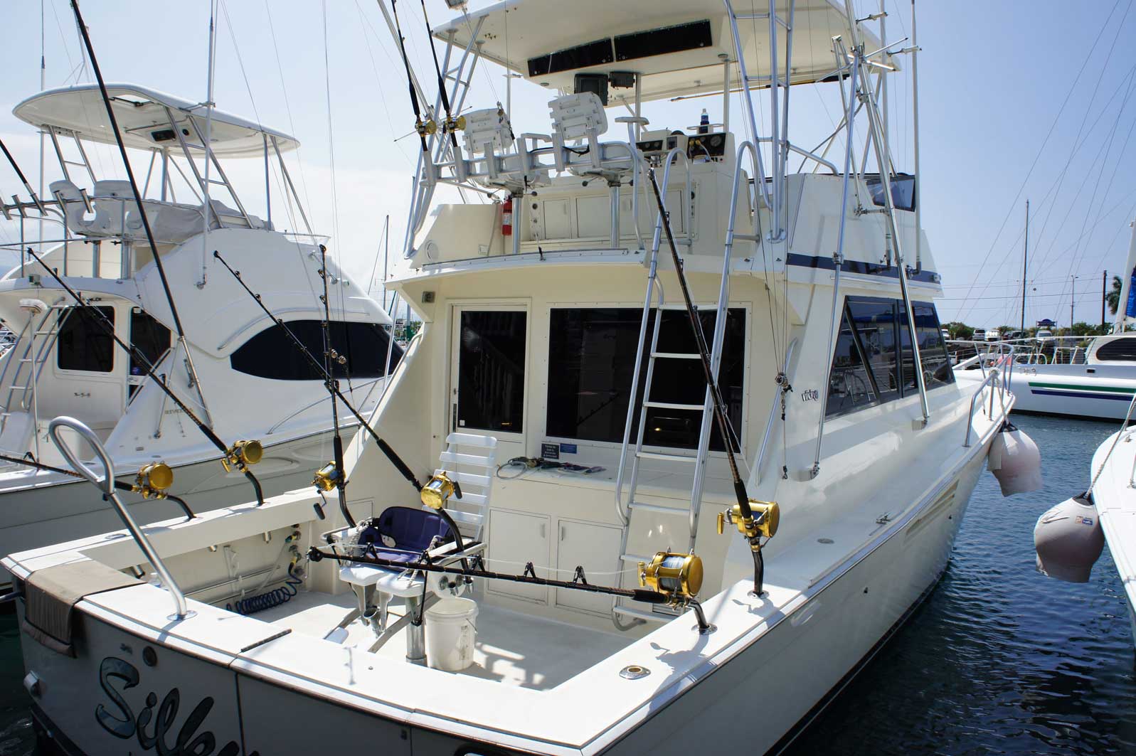 A fishing boat is docked in a marina with other boats
