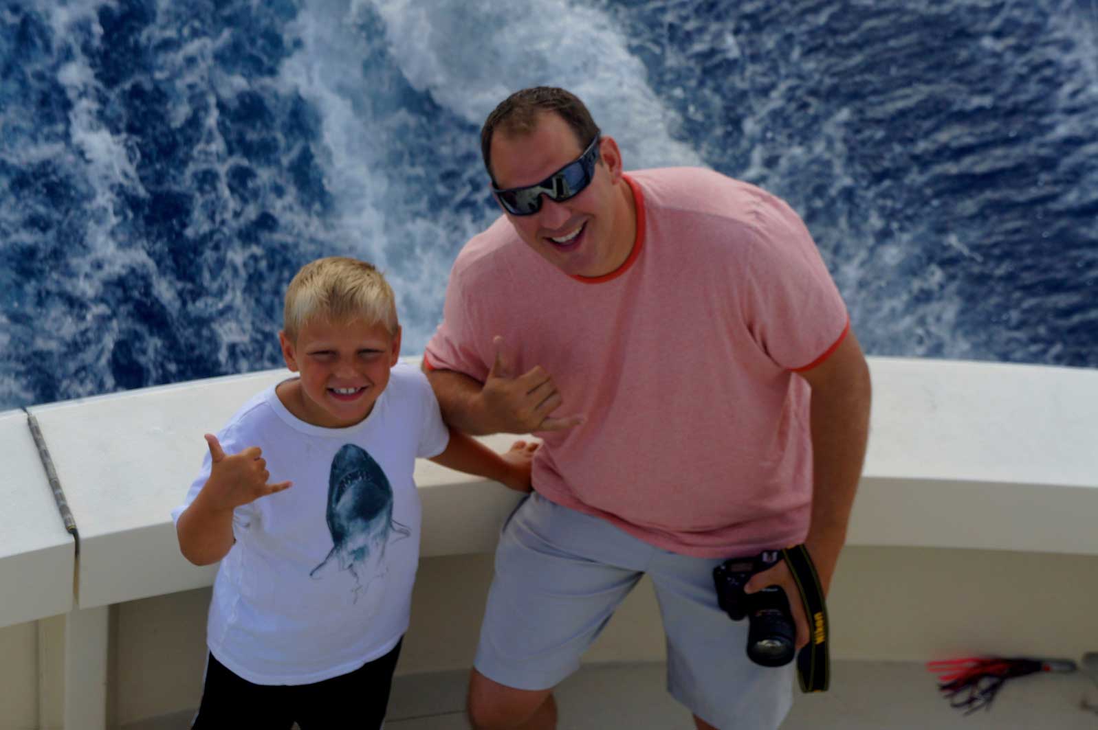 A man and a boy are posing for a picture on a boat.