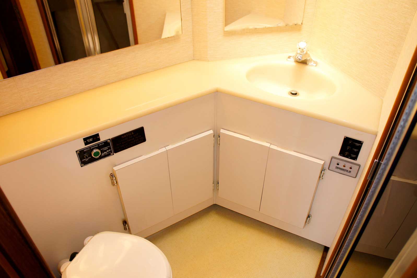 A bathroom with a toilet a sink and a mirror