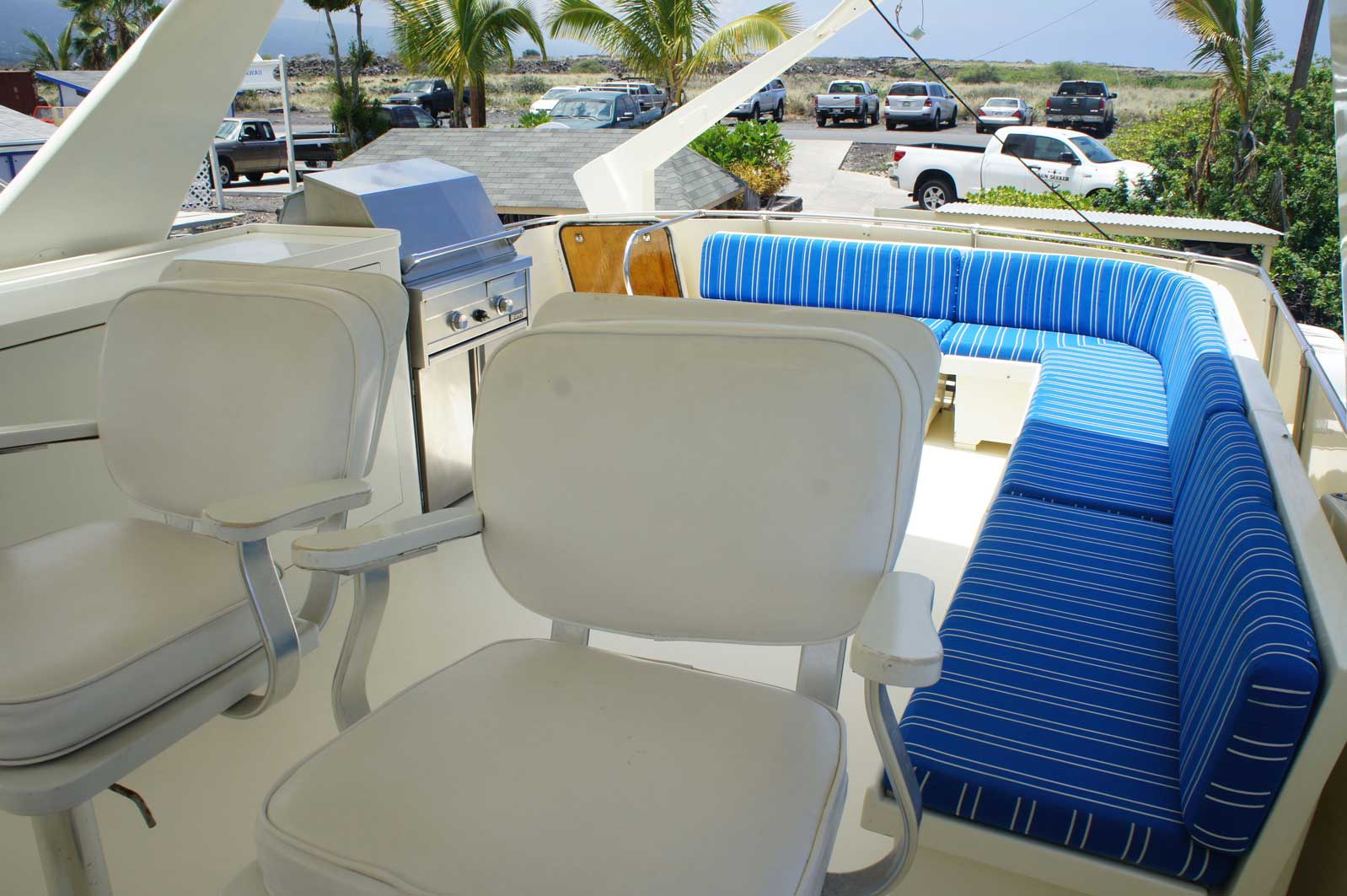 A white chair sits in front of a blue couch on a boat