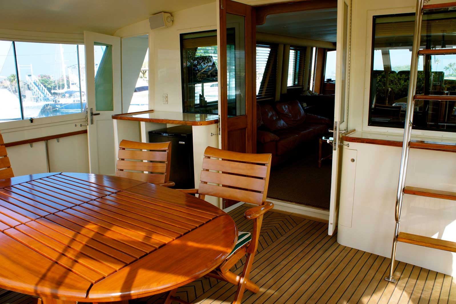 A wooden table and chairs on a deck of a boat