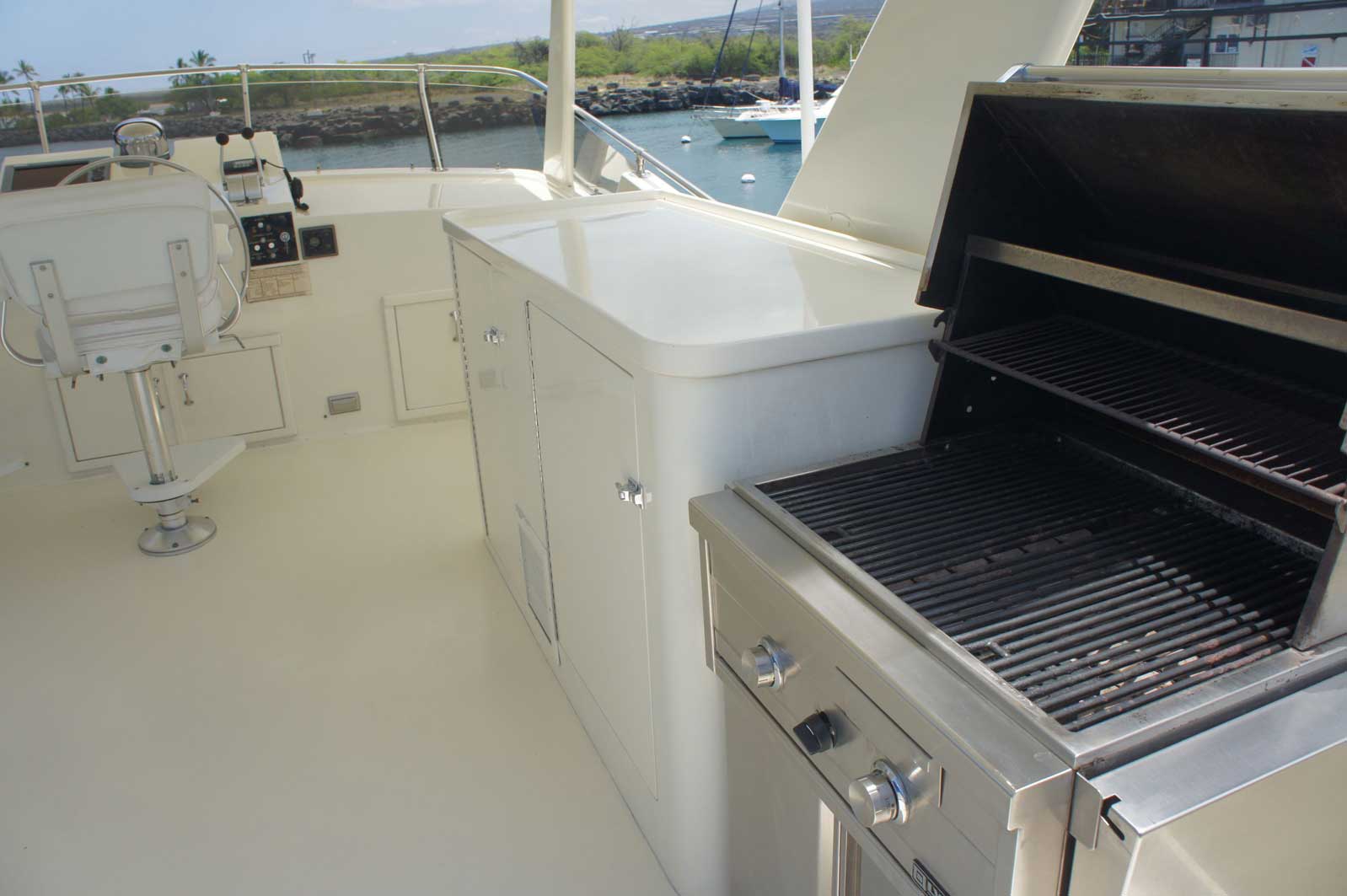 A stainless steel grill is sitting on the deck of a boat.