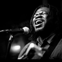 A black and white photo of a man singing into a microphone