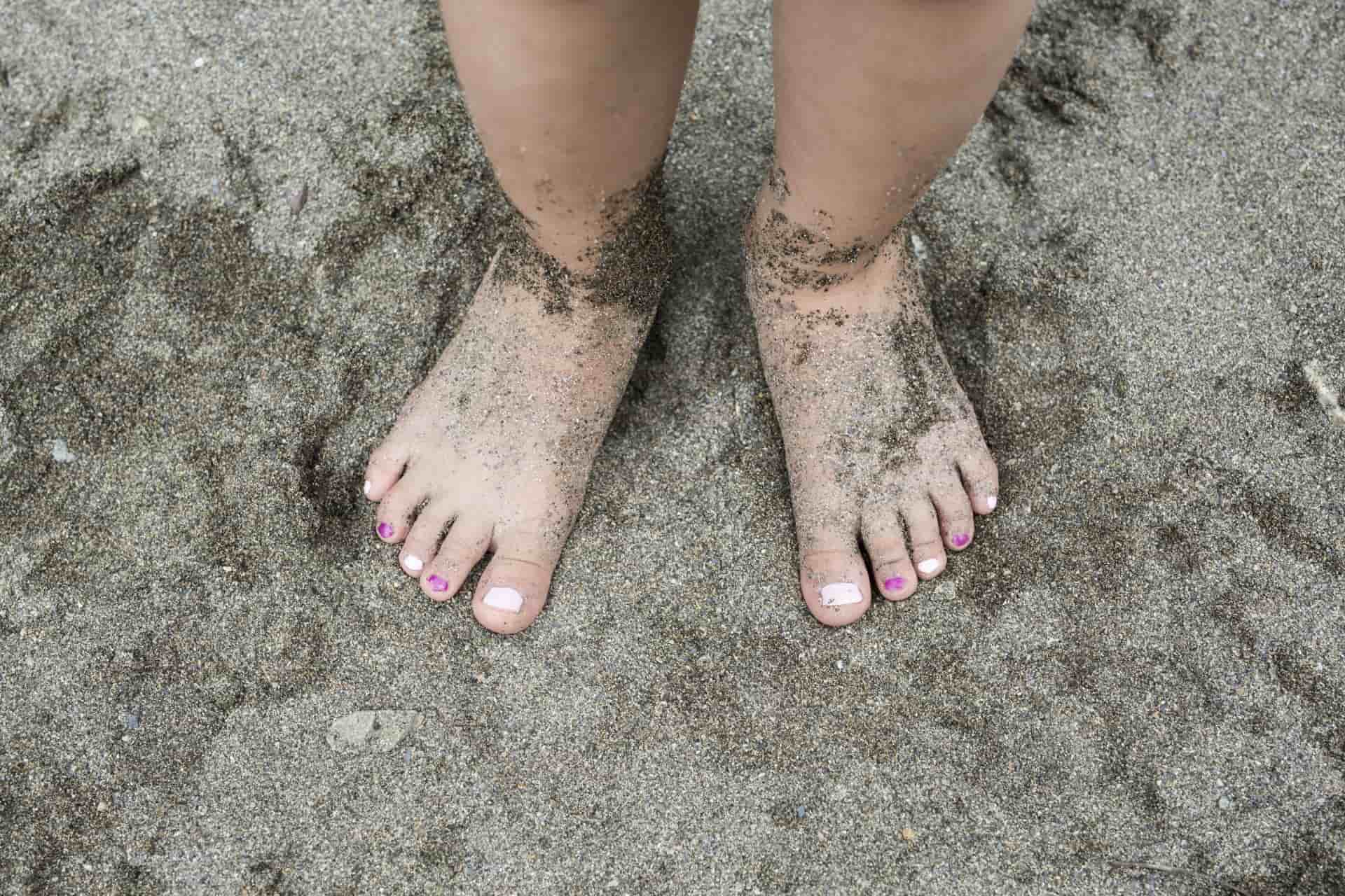 Children's Feet Buried In The Sand - Acacia Podiatry in Parap, NT