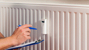 persona consulta la temperatura di un termosifone