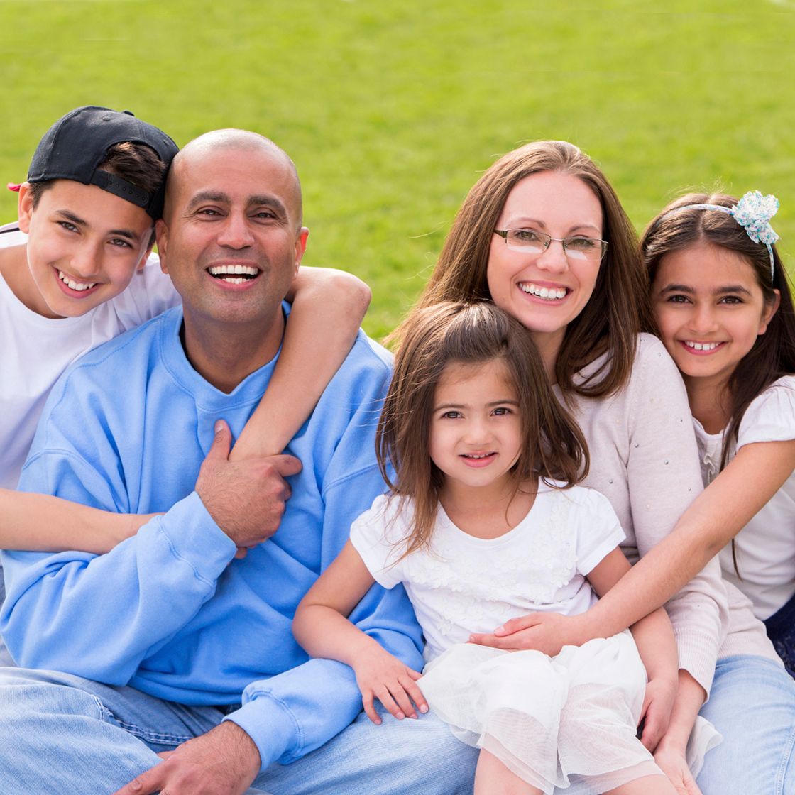 Smiling family with a mom, dad, son, and two daughters