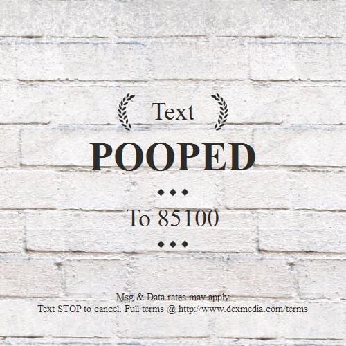 Text ad on a white brick wall: