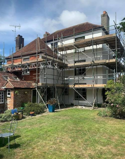 large house with scaffold with a garden