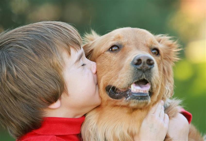 kid kissing his dog