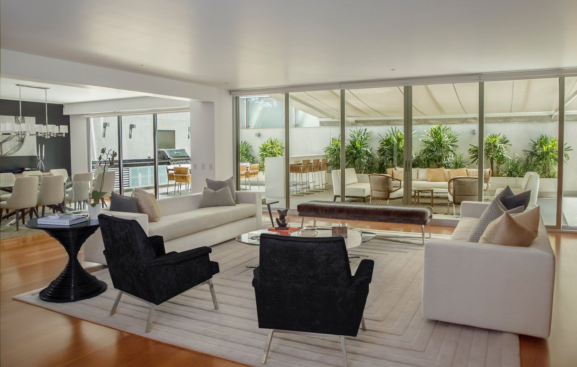 A living room with a white couch and black chairs