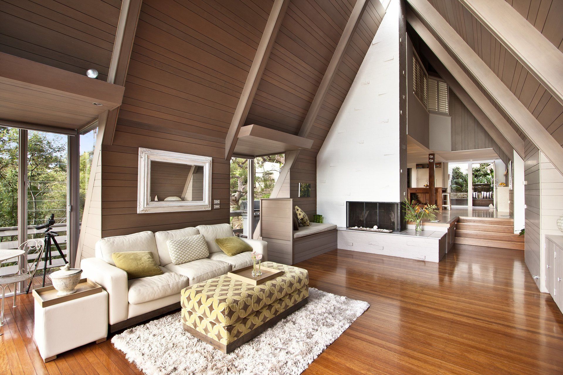 A living room with a couch ottoman and fireplace