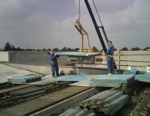 due lavoratori che sollevano delle lamine