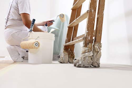 Painter at Work with a Roller, Bucket and Ladder - Remodeling in Burien, WA