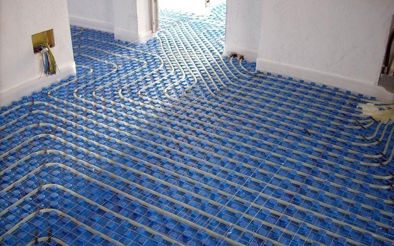 Sistema di riscaldamento a pavimento blu con tubi installati, pronto per la pavimentazione.