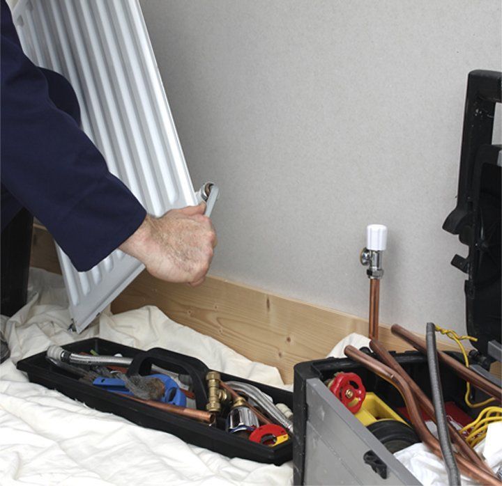 Get your boiler fixed. Serving across Mitcham, Tooting & Sutton Engineer repairing a radiator