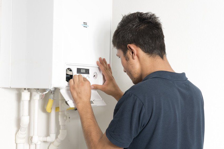 Get your boiler serviced today. Work done throughout Mitcham, Tooting & Sutton Engineer fixing a boiler