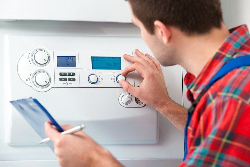 Servicing your boiler in Mitcham, Tooting & Sutton Man fixing a boiler