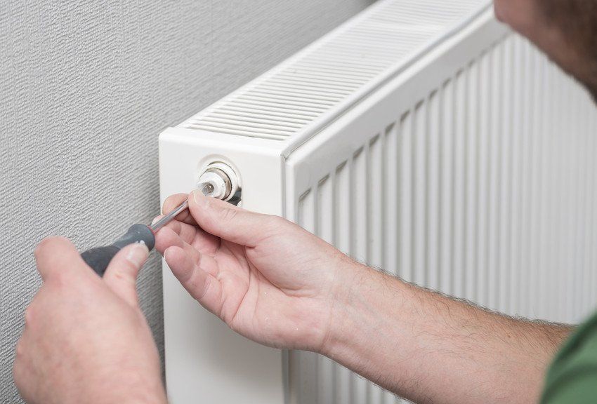 Servicing your boiler in Mitcham, Tooting & Sutton Engineer fixing a boiler