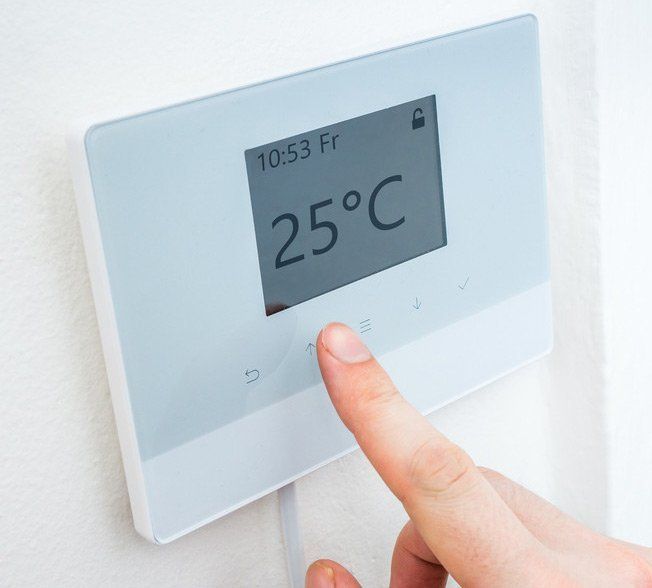 Update your central heating - serving Mitcham, Carshalton and across South London Woman sitting by a radiator