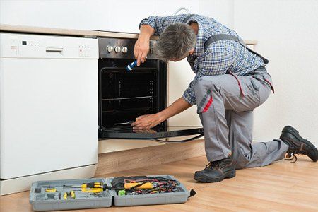 Repairman Examining Oven - Appliance Service in Manalapan, NJ