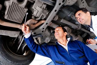 an expert and a mechainic are checking a car