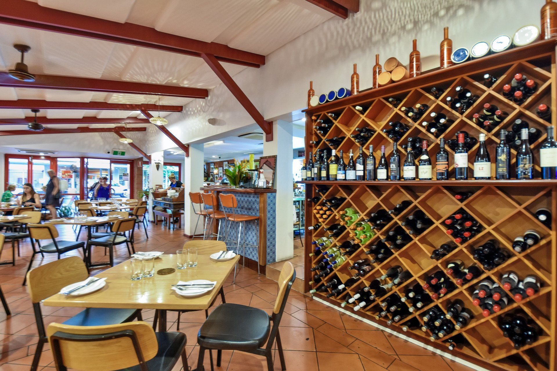 Restaurant interior with tables, chairs, wine rack, and bar.