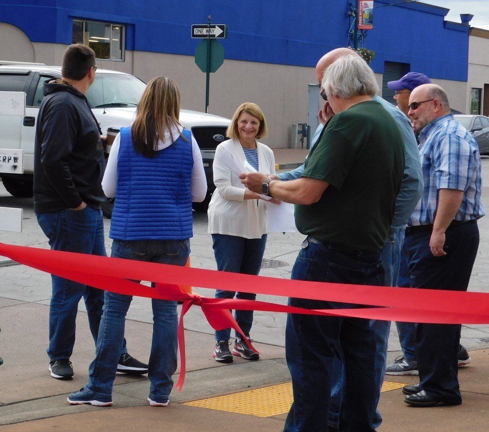 a group of people standing in front of a red ribbon