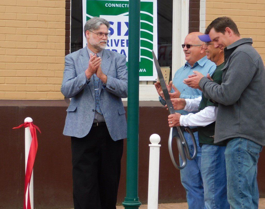 a group of men standing in front of a sign