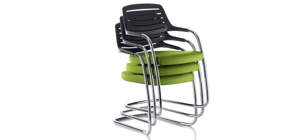 Una pila di quattro sedie moderne con struttura a doghe nere, seduta imbottita verde lime e telaio in metallo argentato.