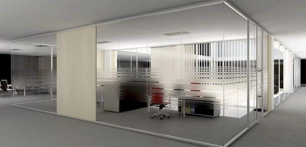 Un moderno interno per ufficio caratterizzato da pareti divisorie in vetro con strisce orizzontali satinate e dettagli in legno chiaro.