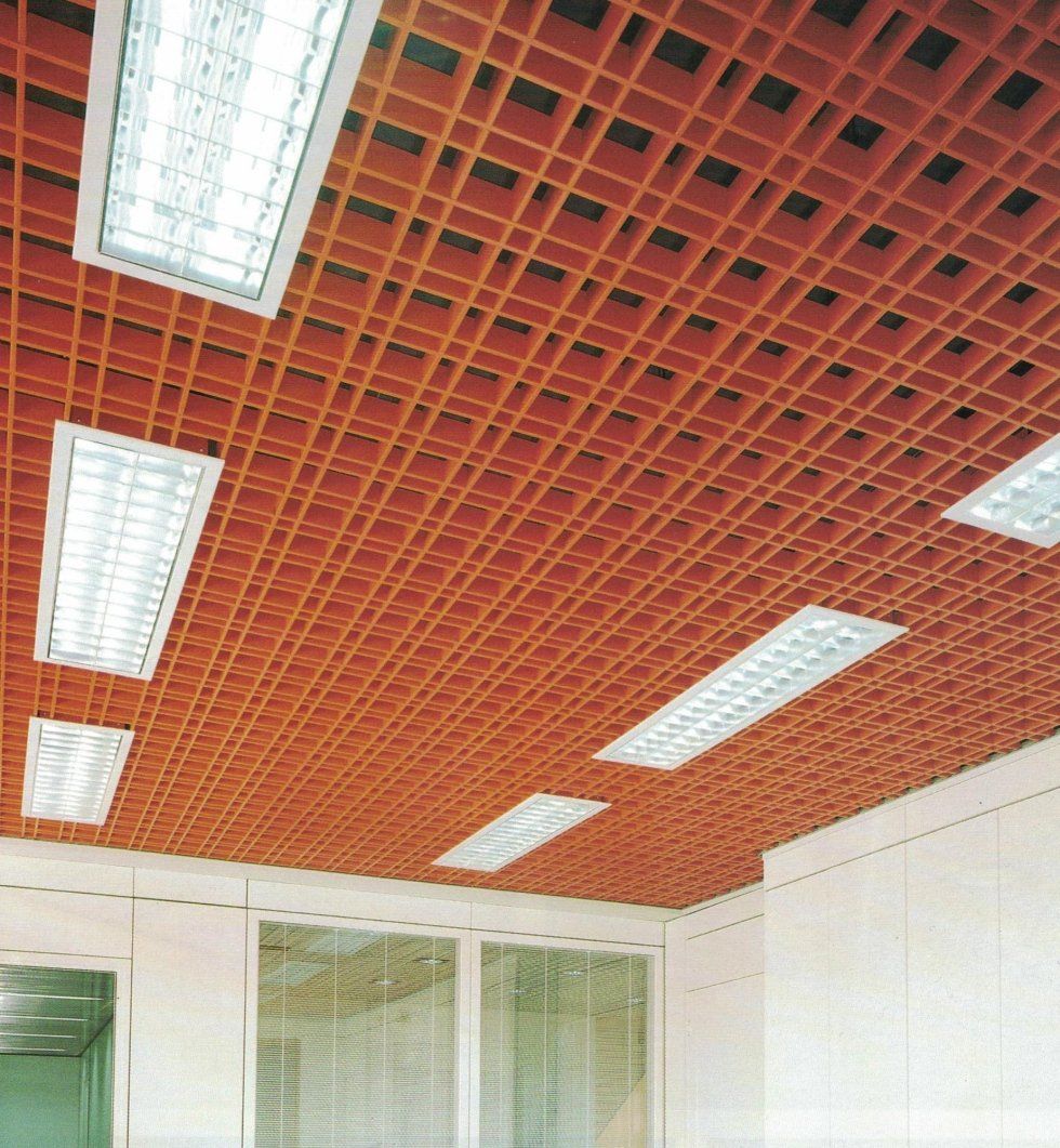Un controsoffitto a griglia di colore marrone rossastro con diverse plafoniere fluorescenti rettangolari integrate.
