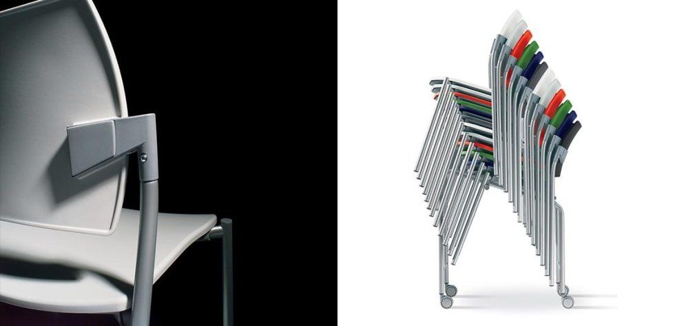Primo piano di una moderna sedia grigio chiaro accanto a una pila di sedie colorate su sfondo bianco.