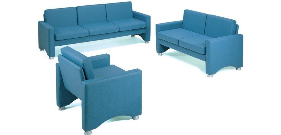 Un set di tre mobili moderni, imbottiti e di colore blu tinta unita, composto da un divano, una poltrona a due posti e una poltrona singola.