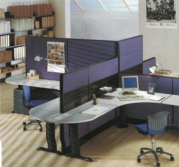 Un moderno ufficio con postazioni di lavoro a cubicolo, pareti divisorie viola, scrivanie grigio chiaro e sedie ergonomiche blu.