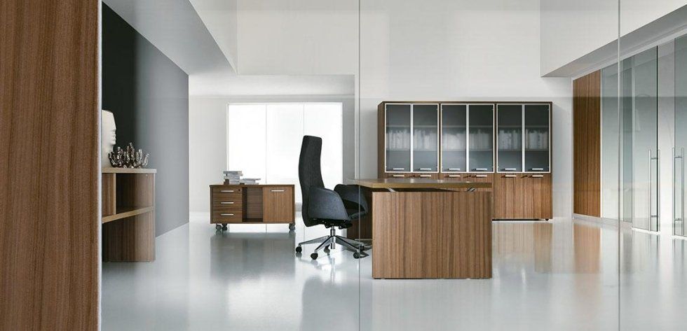 Un ufficio moderno e minimalista con scrivania color legno, sedia girevole nera e mobili contenitori coordinati.