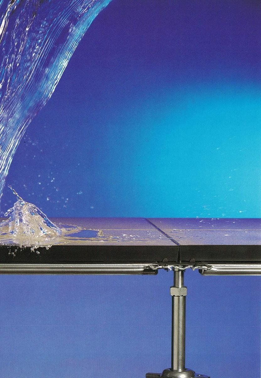 Schizzi d'acqua su una superficie orizzontale scura contro uno sfondo sfumato di blu.
