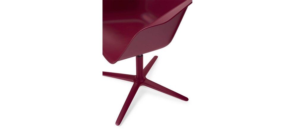 Una sedia moderna di colore rosso scuro con seduta sagomata a secchiello e base a piedistallo a quattro gambe.
