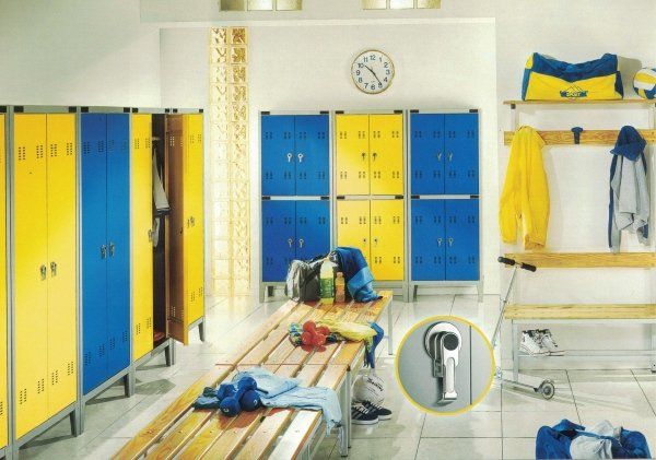 Uno spogliatoio con armadietti blu e gialli, panche di legno e un'area per appendere l'attrezzatura. Include un primo piano di un chiavistello.