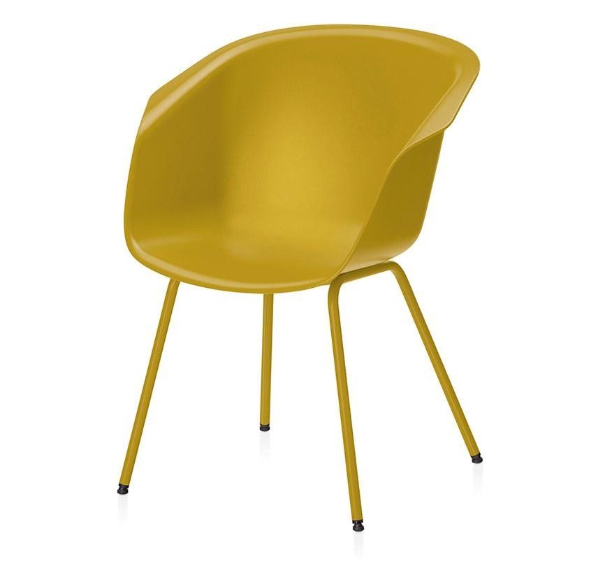 Una sedia a conchiglia color giallo senape con seduta arrotondata e quattro sottili gambe in metallo dello stesso colore, su sfondo bianco.