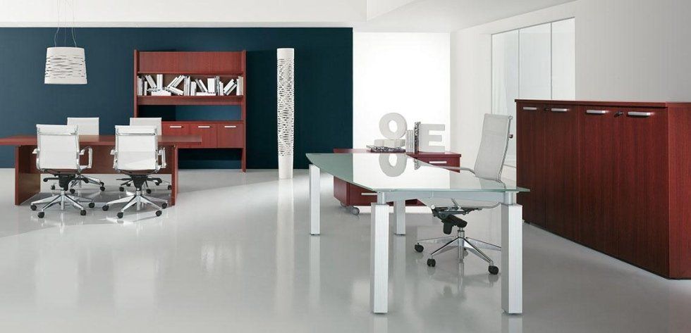 Ufficio moderno con scrivanie in vetro e legno di ciliegio, sedie girevoli bianche e armadietti coordinati, in un ambiente luminoso.