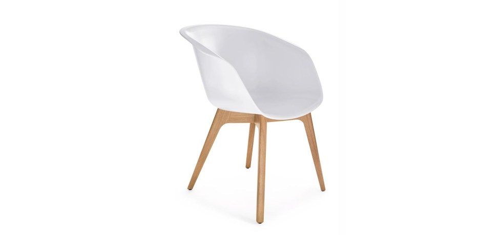 Una moderna sedia bianca a forma di conchiglia con gambe in legno chiaro, vista di profilo su sfondo bianco.