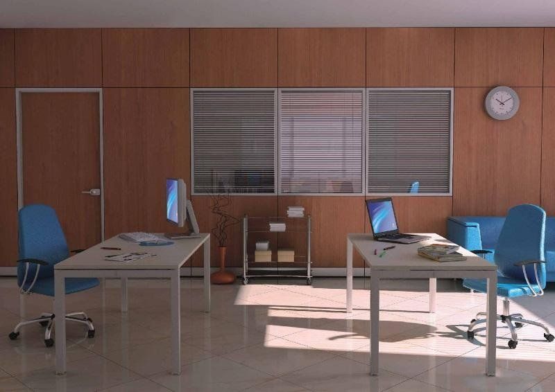 Ufficio moderno con due scrivanie, sedie blu, un computer, un laptop, scaffali in metallo e un orologio da parete su pareti rivestite in legno.