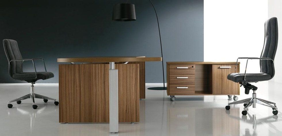 Un moderno set da ufficio con scrivania in legno, due sedie girevoli in pelle nera, un mobile contenitore su ruote e una lampada da terra alta.